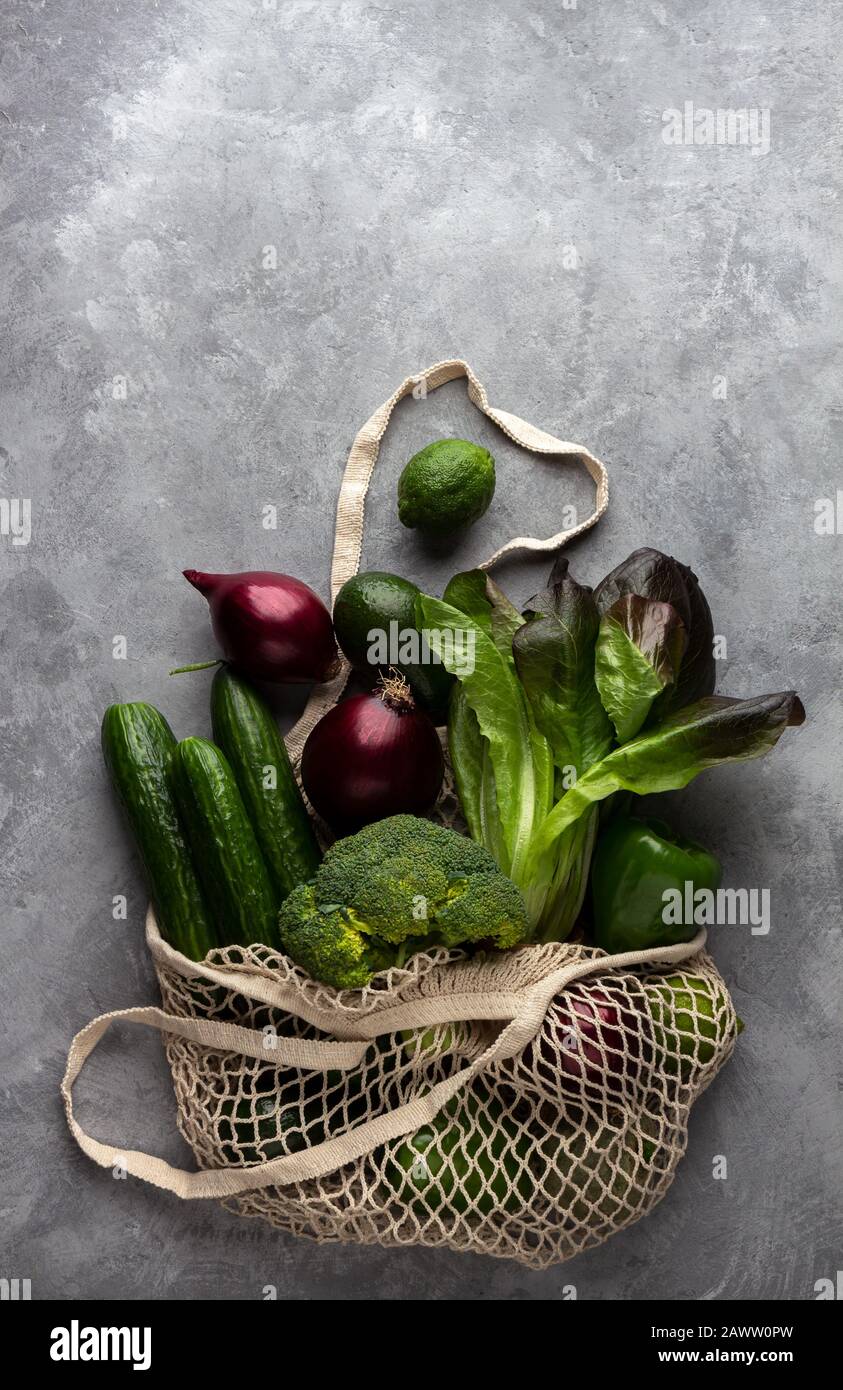 Frisches Gemüse und Obst in einem Saitenbeutel auf Betongrund. Das Konzept des Umweltschutzes und der gesunden Ernährung, Draufsicht Stockfoto