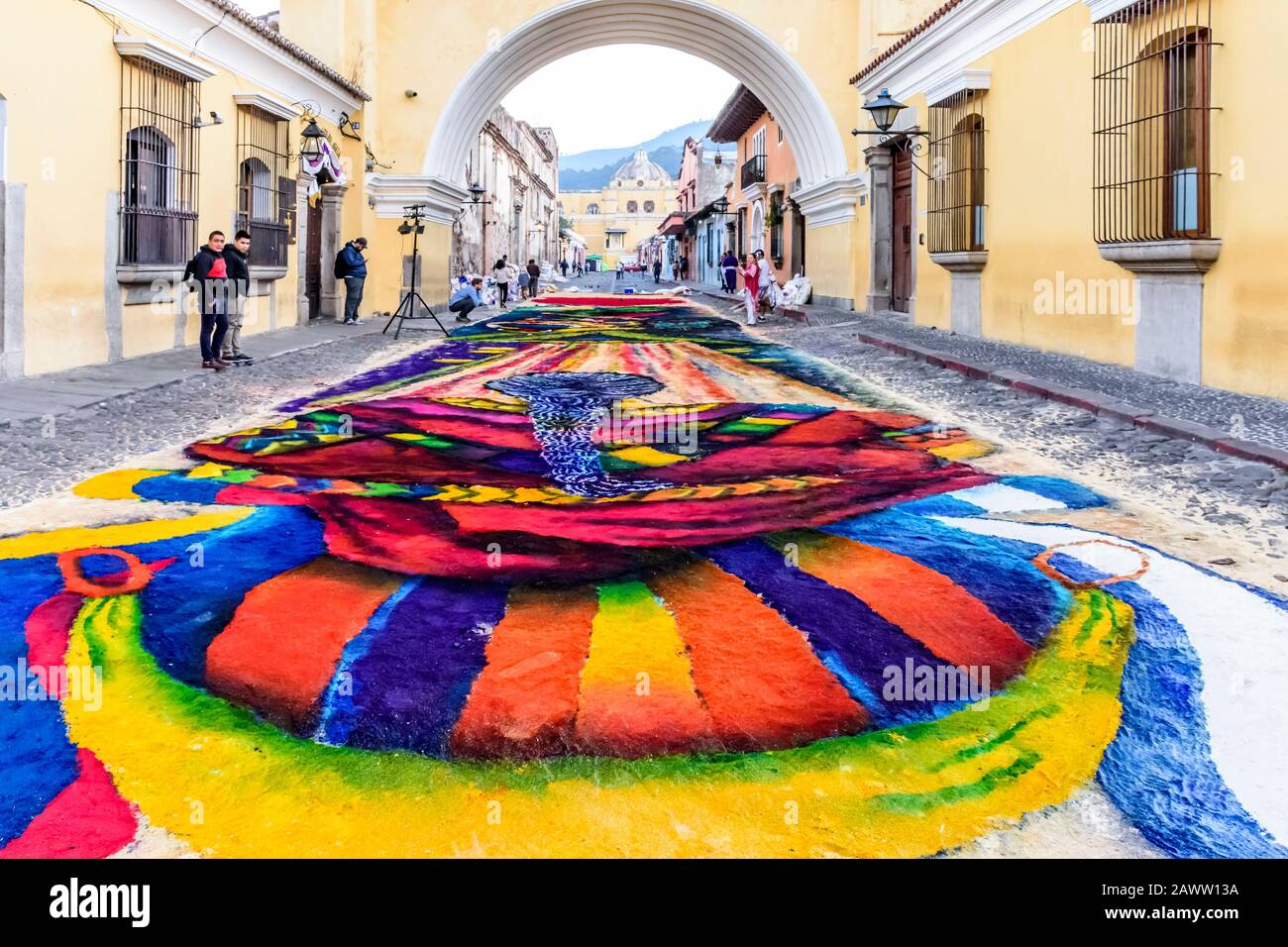 Antigua, Guatemala - 14. April 2019: Herstellung von gefärbtem Sägemehl Palme Sonntag Prozession Teppich unter Arco de Santa Catalina in der UNESCO-Welterbestätte. Stockfoto