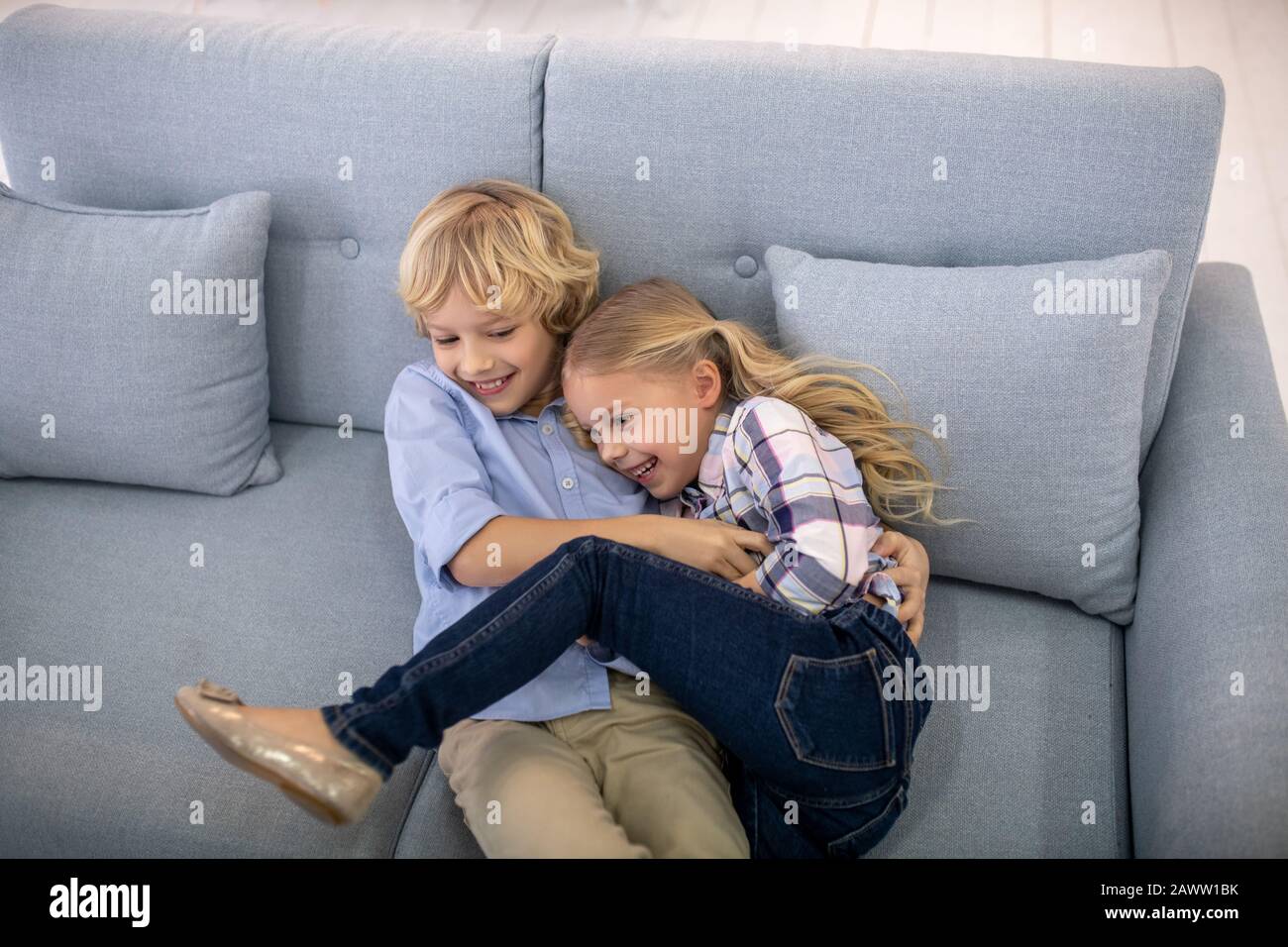 Junge und Mädchen kichern, kitzeln sich gegenseitig Stockfoto