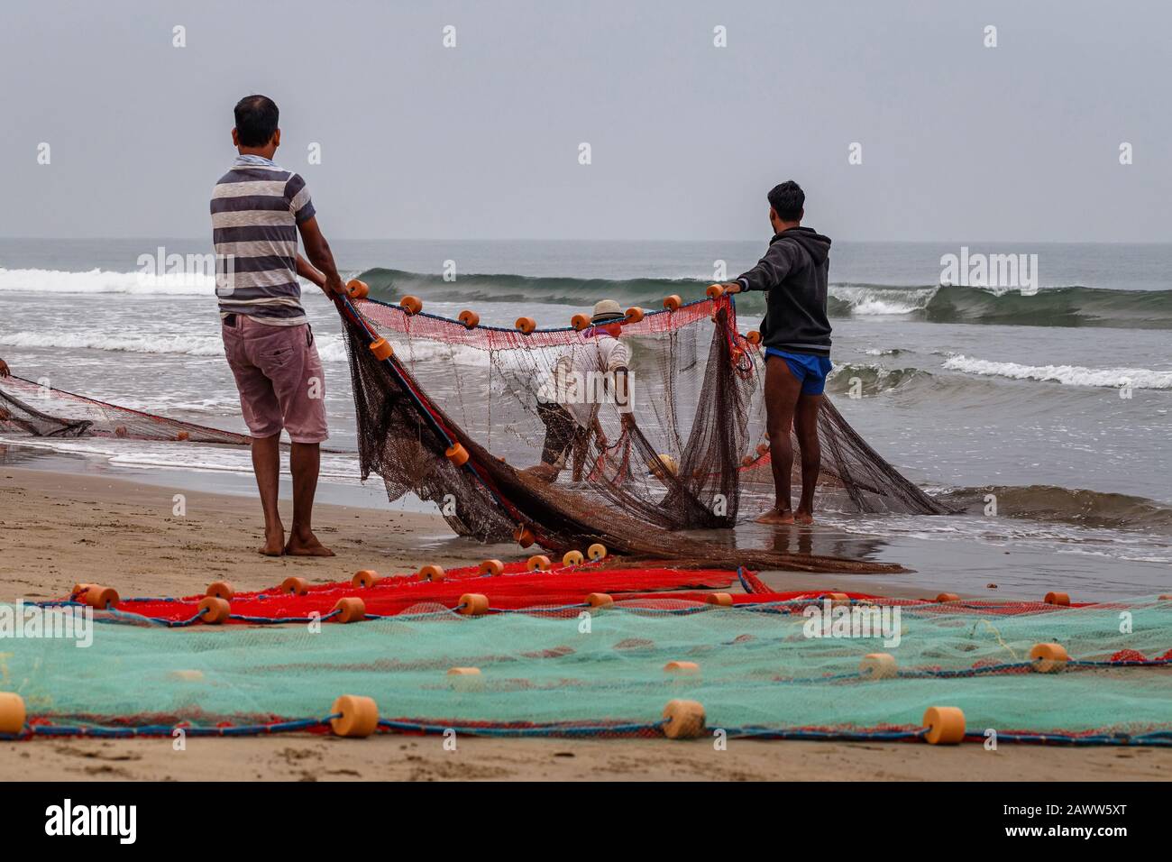 Arambol, GOA, INDIEN - 17. JANUAR: Fischer an der Küste ziehen Netze aus. Morgen auf See. Arambol, Goa, Indien Stockfoto