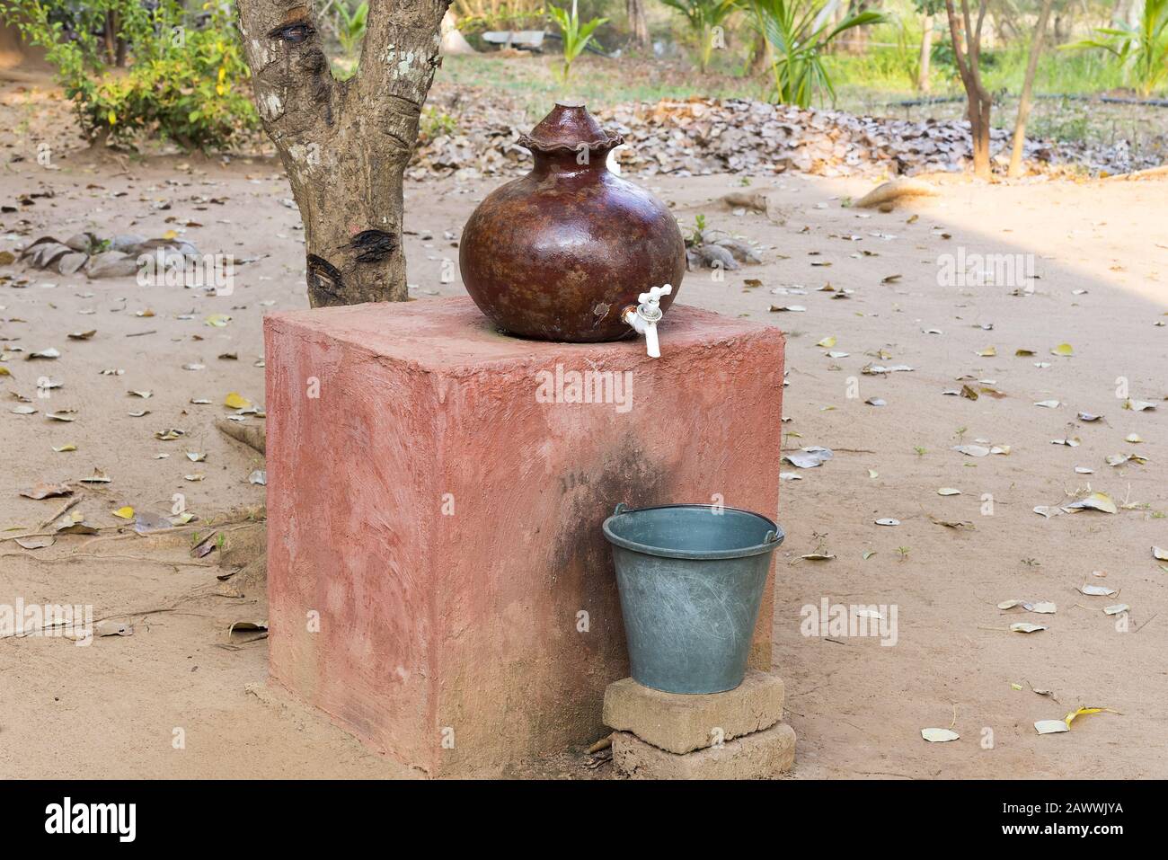 Steingut Topf handgemacht und zum halten von Trinkwasser mit Plastikeimer zum Sammeln von Tropfen verwendet. Stockfoto