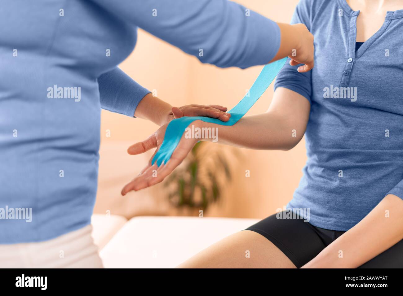 Physiotherapeutin, die Kinesio-Klebeband auf den Arm des Patienten auftragen. Kinesiologie, Physiotherapie, Rehabilitationskonzept. Seitenansicht für zugeschnittene Aufnahmen. Stockfoto