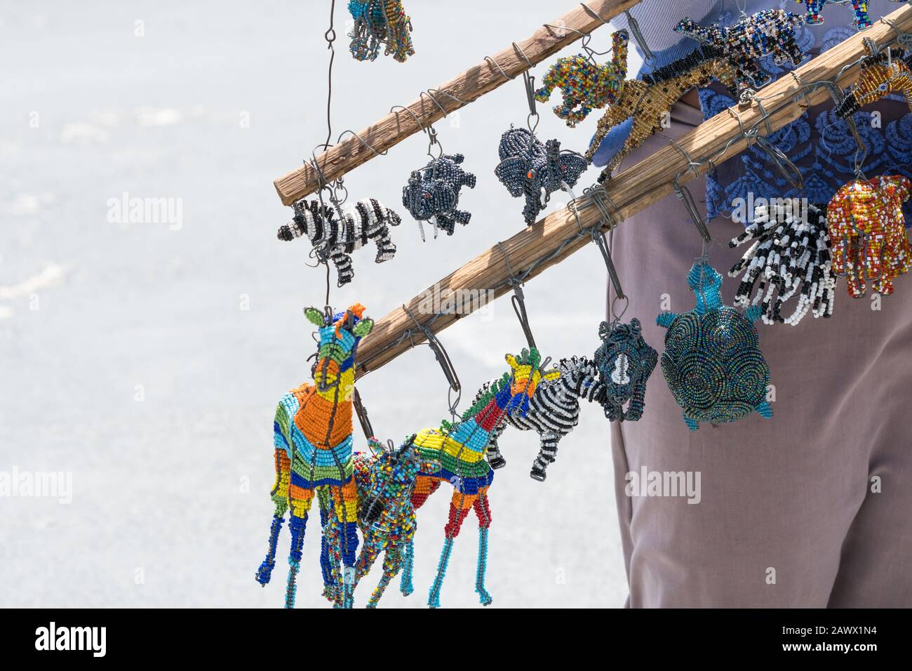 Traditionelles handgemachtes afrikanisches Kunsthandwerk, Souvenirs, Erinnerungsstücke, Kurios, Schmuckstücke, die an einem Gebäude hängen, das vom Straßenhändler in Kapstadt, Südafrika gehalten wird Stockfoto
