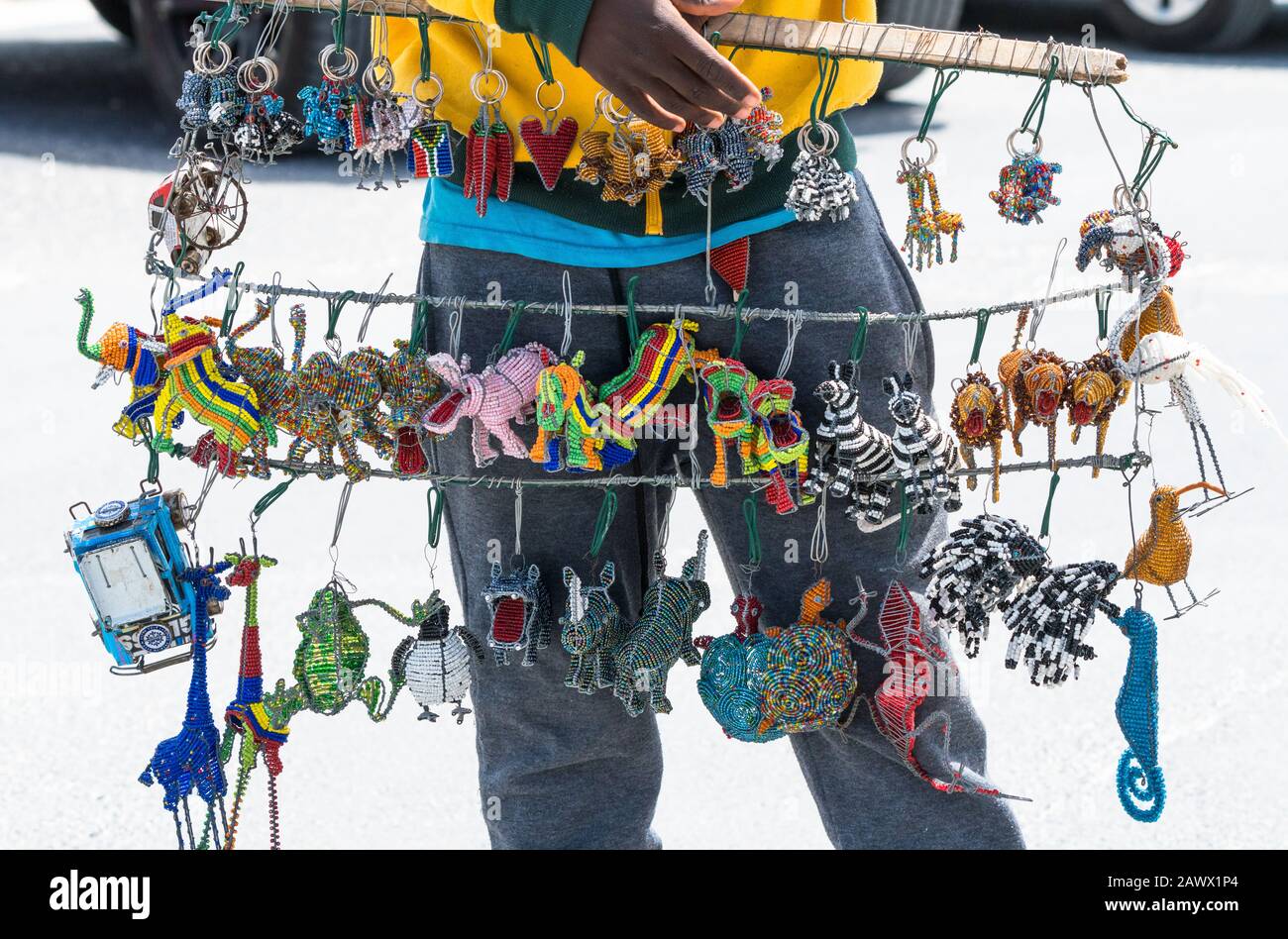Afrikanische Souvenirs, Kuriositäten, Perlen, Gegenstände, Andenken, Kunsthandwerk, Schmuckstücke, die an Drahtstrukturen hängen, die von Straßenverkäufern in Südafrika aufgefangen werden Stockfoto