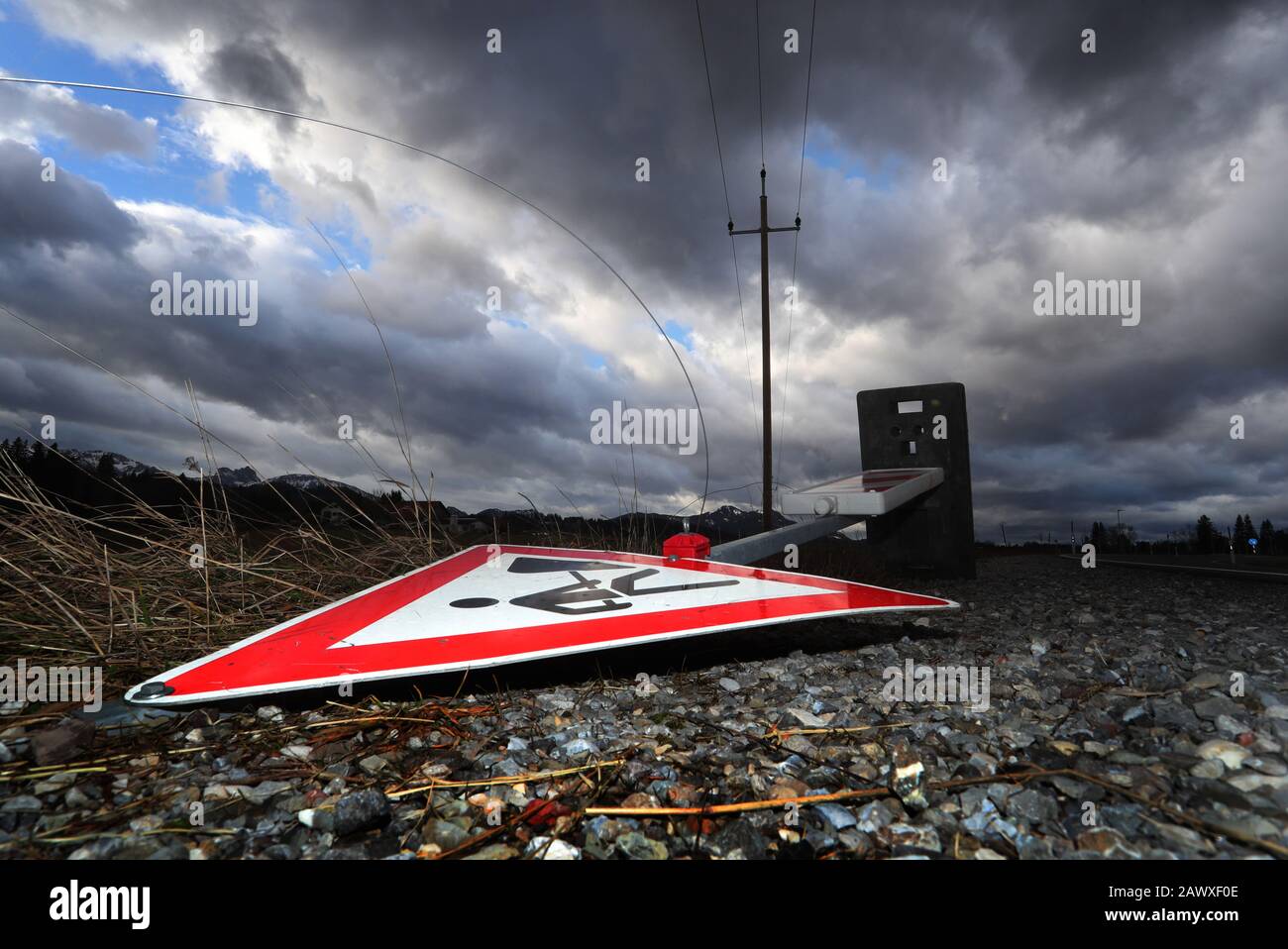 Seeg, Deutschland. Februar 2020. Ein Schild auf der Baustelle liegt überkippt vom Sturm 'Sabine' unter einem bewölkten Himmel auf einer Straße. Kredit: Karl-Josef Hildenbrand / dpa / Alamy Live News Stockfoto