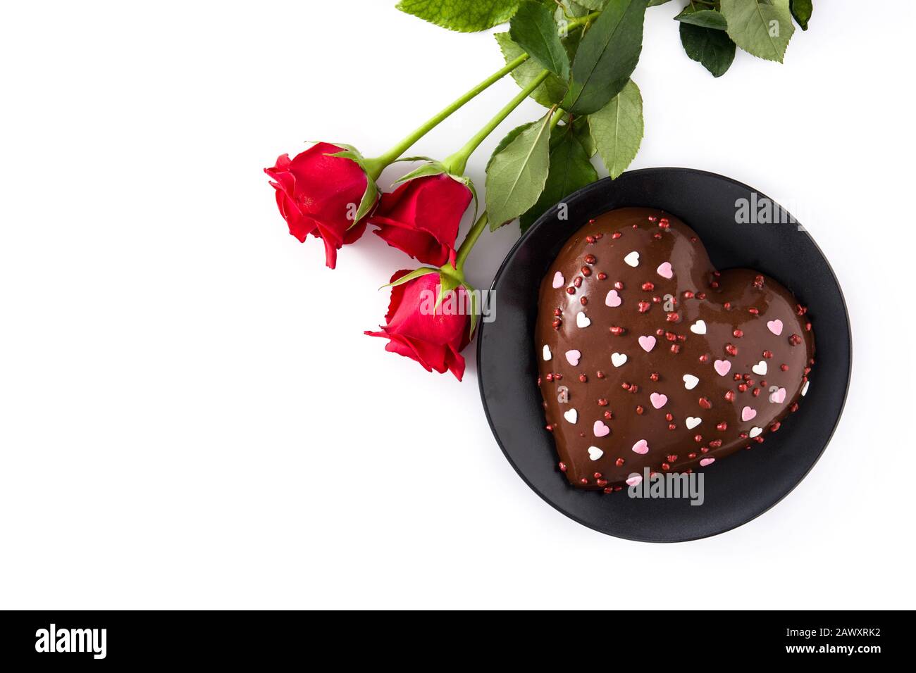 Herzförmige Kuchen und rote Rosen zum Valentinstag oder Muttertag isoliert auf weißem Hintergrund. Draufsicht. Kopierbereich Stockfoto