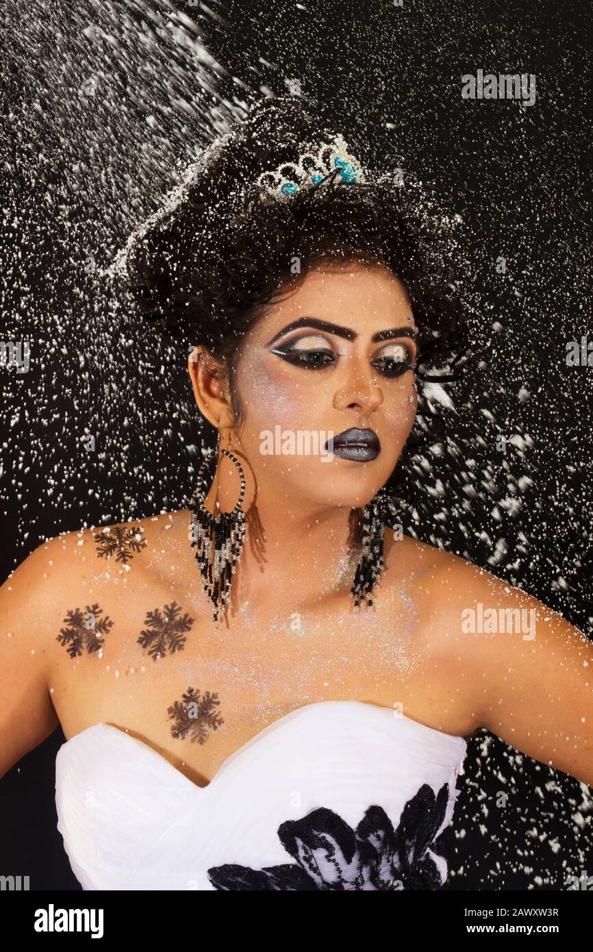 Modestudio Porträt der schönen Frau in schwarz-weißem Gown mit afro Locken Frisur. Mit einem Tiara mit silberfarbenem Konfettihintergrund Stockfoto