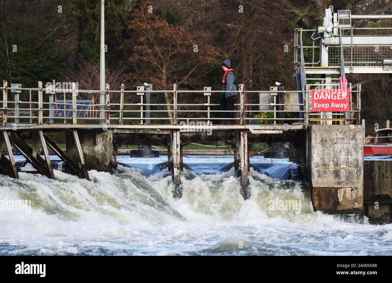 Ein Mitarbeiter der Umweltbehörde spaziert nach Storm Ciara, der das Land am Sonntag in die Stadt führte, über das Wehr bei Ray Mill Island, Maidenhead, Berkshire. Stockfoto