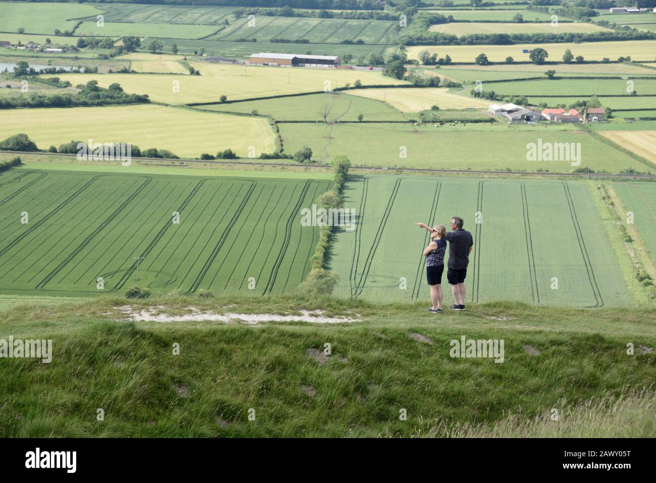 Paar zu Fuß im Britton Camp und Aussicht, Wiltshire, Großbritannien Stockfoto