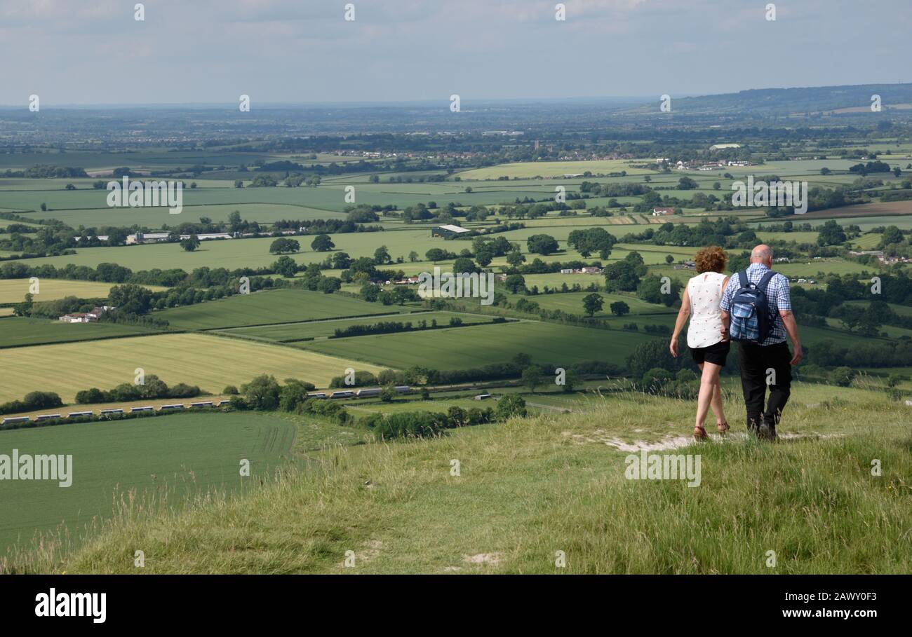 Paar zu Fuß im Britton Camp und Aussicht, Wiltshire, Großbritannien Stockfoto