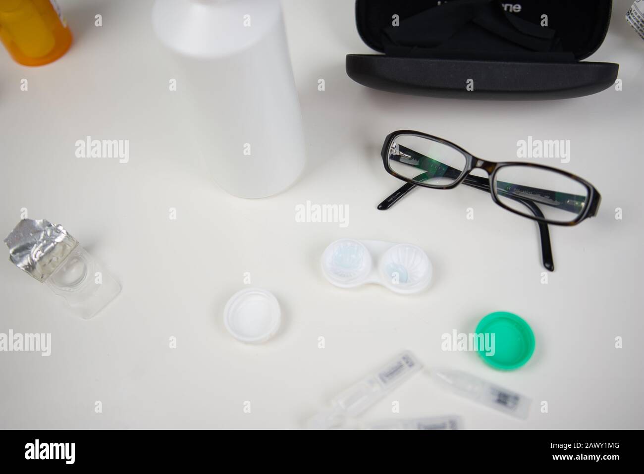 Kontaktlinsengehäuse mit Brille, Tasche, Rahmen und Tropfen flach auf weißem Hintergrund der Gegenplatte Stockfoto
