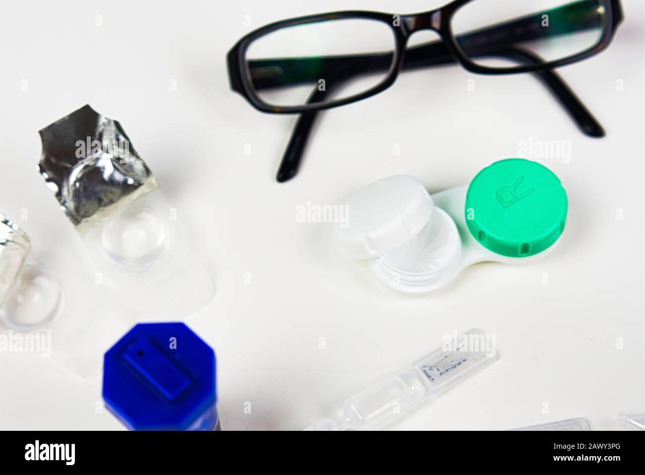 Kontaktlinsengehäuse in flacher Laienform mit anderen Augenpflegeprodukten wie Brille, Tropfen und anderen Fällen Stockfoto