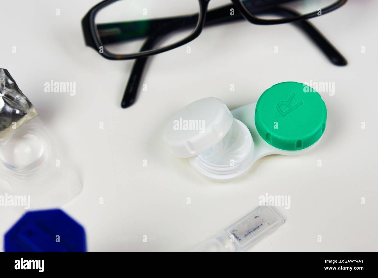 Kontaktlinsengehäuse in flacher Laienform mit anderen Augenpflegeprodukten wie Brille, Tropfen und anderen Fällen Stockfoto
