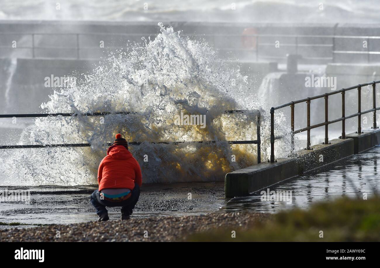 Shoreham UK, 10. Februar 2020 - EIN Wanderer beobachtet, wie die Wellen am Eingang des Shoreham Harbour in Sussex einbrechen, während das Schlussende von Storm Ciara nach und nach durch Großbritannien bläst, nachdem er am Wochenende den Großteil des Landes gebeutelt hatte: Credit Simon Dack/Alamy Live News Stockfoto
