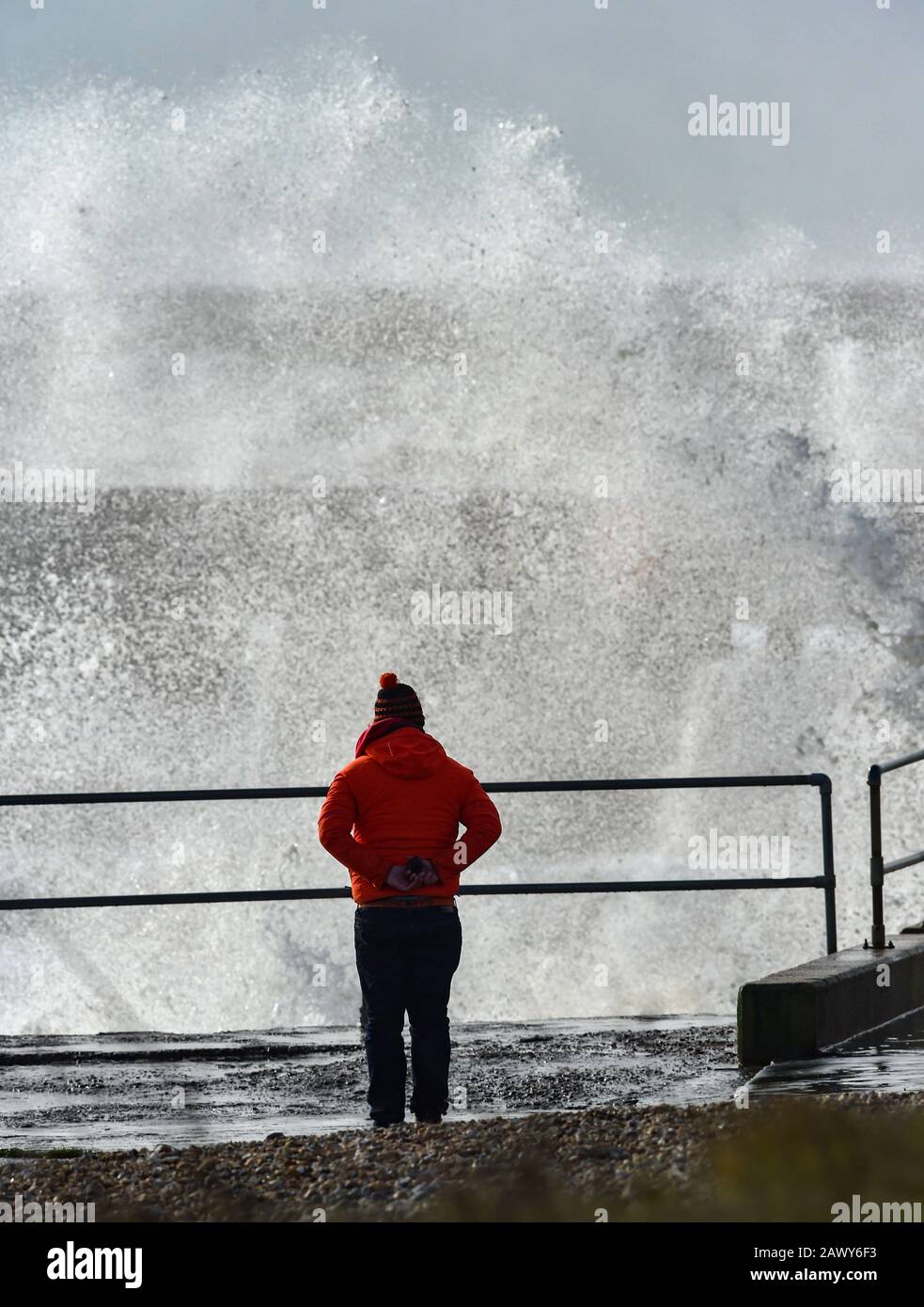 Shoreham UK, 10. Februar 2020 - EIN Wanderer beobachtet, wie die Wellen am Eingang des Shoreham Harbour in Sussex einbrechen, während das Schlussende von Storm Ciara nach und nach durch Großbritannien bläst, nachdem er am Wochenende den Großteil des Landes gebeutelt hatte: Credit Simon Dack/Alamy Live News Stockfoto
