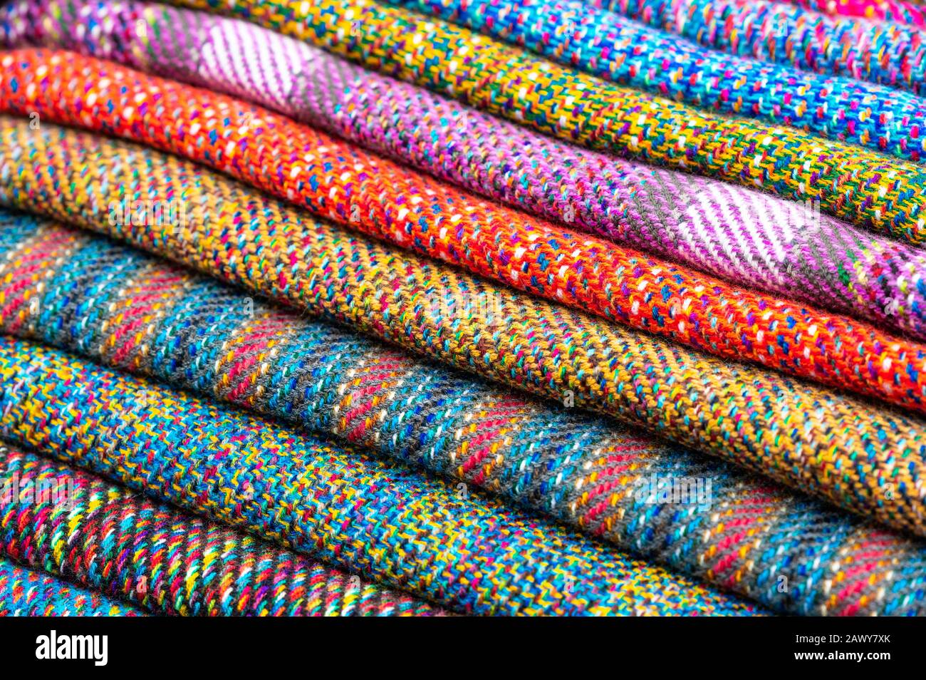 Ein Haufen bunter traditioneller Anden-Textilien auf dem lokalen indigenen Markt Otavalo, Ecuador. Diese Art von Stoffen findet man in Bolivien und Peru. Stockfoto