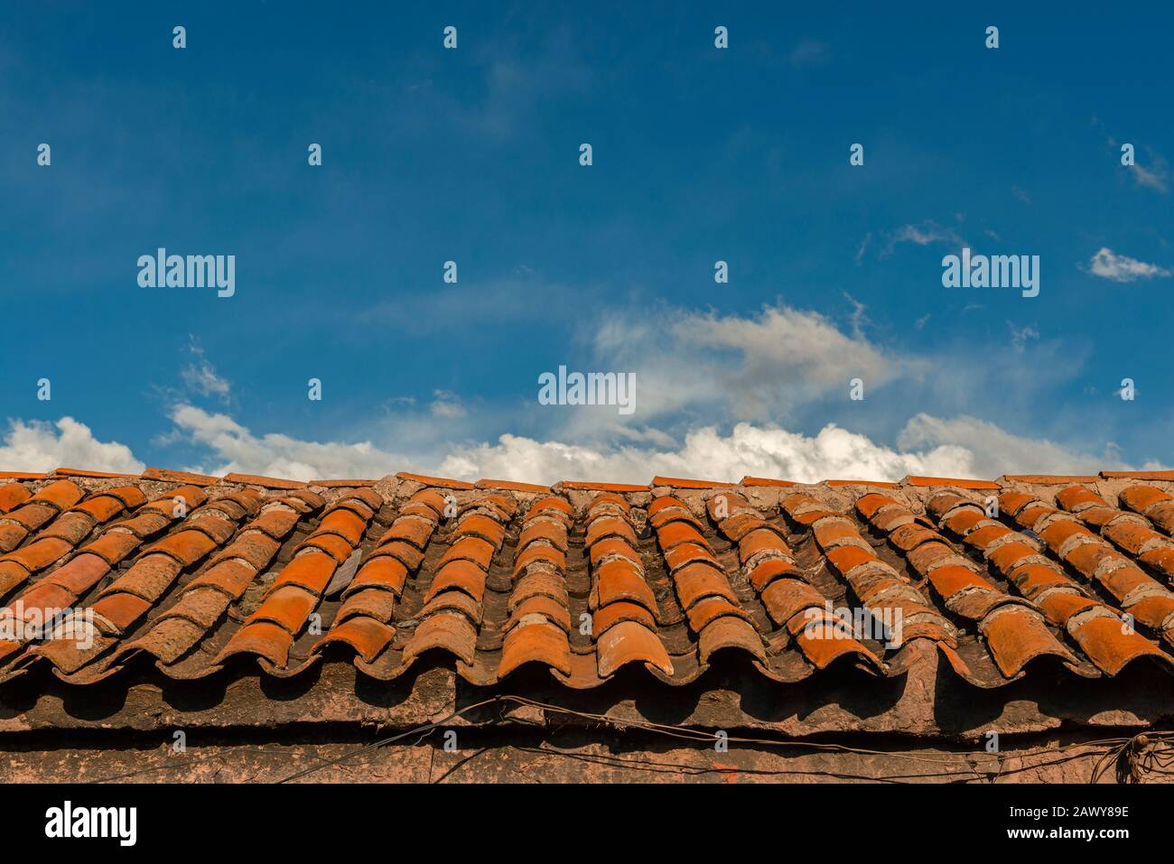 Traditionelle Dacharchitektur im Kolonialstil in der Stadt Cusco mit den farbenfrohen roten Dachziegeln bei Sonnenaufgang, Peru. Stockfoto