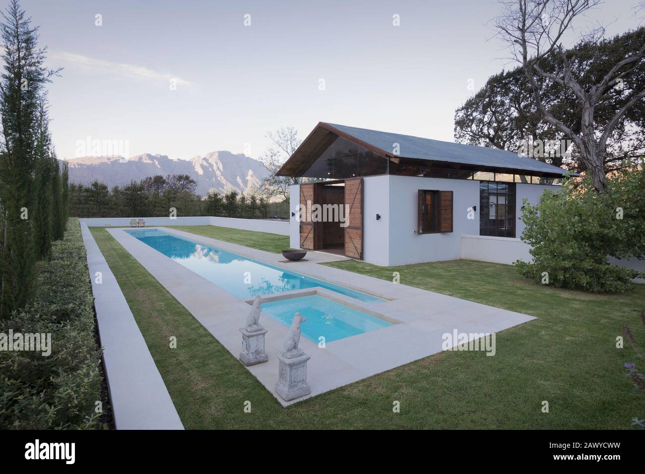 Idyllischer, luxuriöser Pool und Poolhaus mit Bergen im Hintergrund Stockfoto