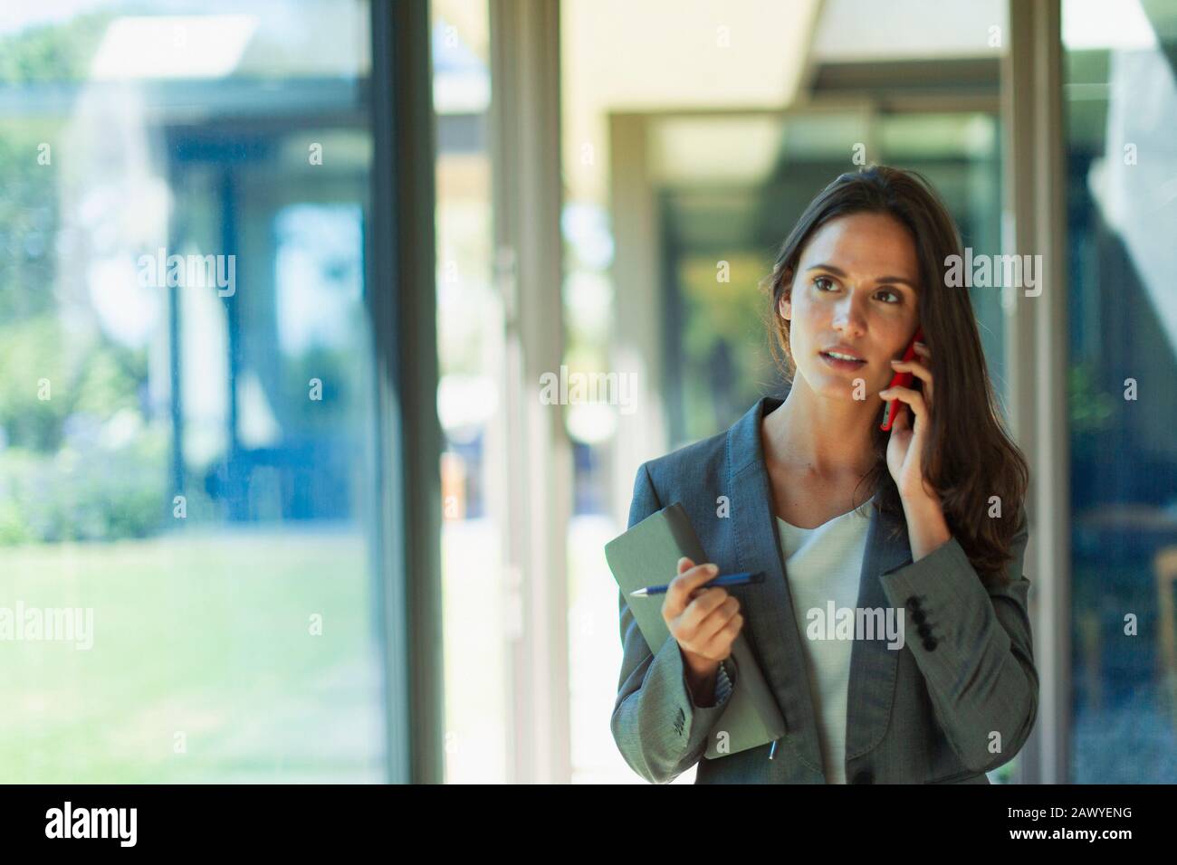 Geschäftsfrau, reden über Handy im Korridor Stockfoto