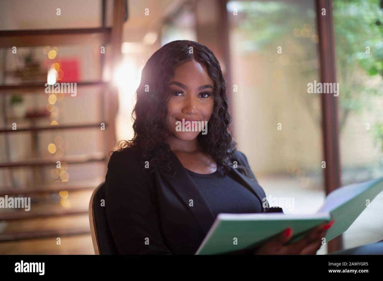 Portrait selbstbewusste junge Frau liest Buch Stockfoto