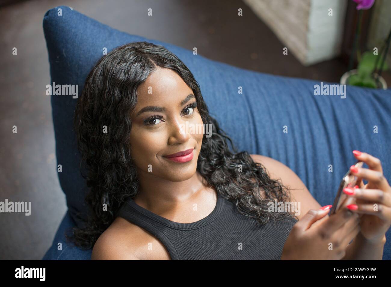 Portrait selbstbewusste, schöne junge Frau mit Smartphone Stockfoto