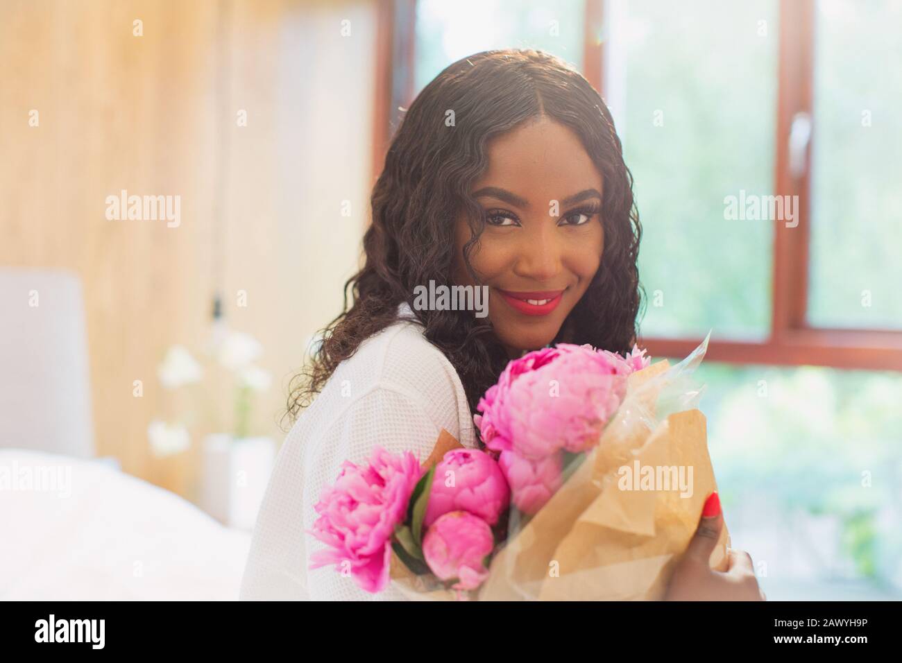 Portrait schöne junge Frau mit Blumenstrauß aus rosa Pony Blumen Stockfoto
