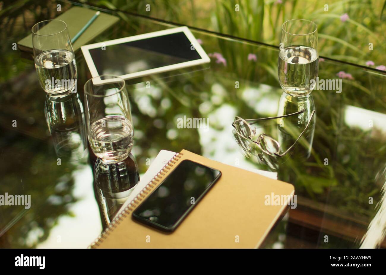 Smartphone und Notebook auf dem Tisch mit Wassergläser Stockfoto