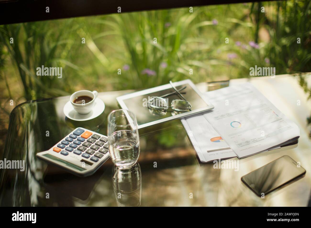 Taschenrechner und digitales Tablett auf dem Tisch mit Kaffee und Papierkram Stockfoto