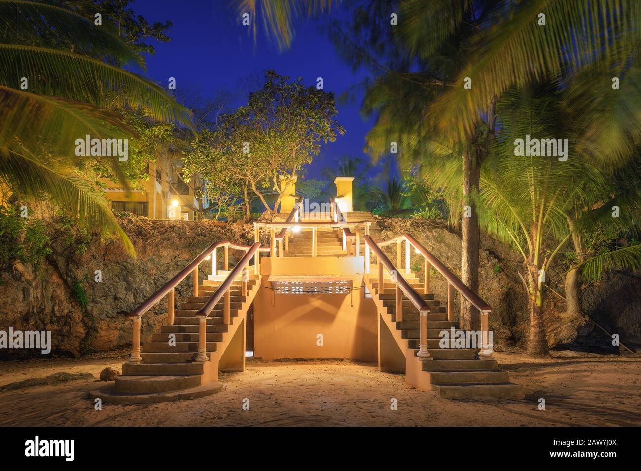Beleuchtete Treppen im wunderschönen tropischen Wald in der Sommernacht Stockfoto