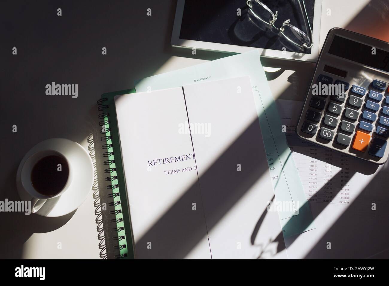 Altersvorsorge am Sonnentisch mit Kaffee und Taschenrechner Stockfoto