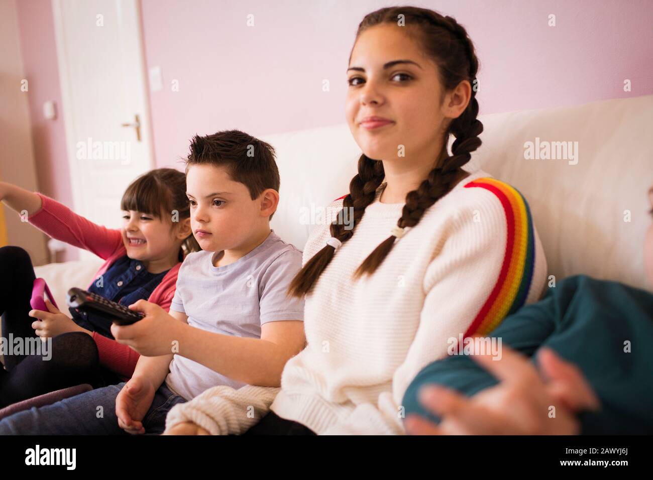 Portrait lächelnde Mädchen Fernsehen mit Geschwistern auf dem Sofa Stockfoto