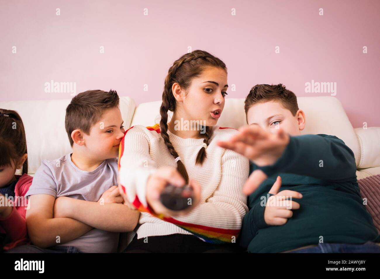Geschwister mit Fernbedienung zum Fernsehen auf dem Sofa Stockfoto