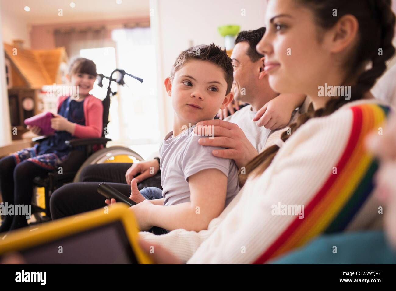 Junge mit Down-Syndrom Fernsehen mit Familie Stockfoto