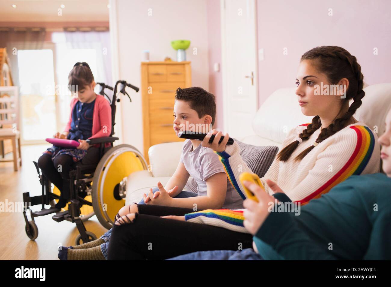 Familie mit Kind Im Down-Syndrom, die im Wohnzimmer Fernsehen Stockfoto