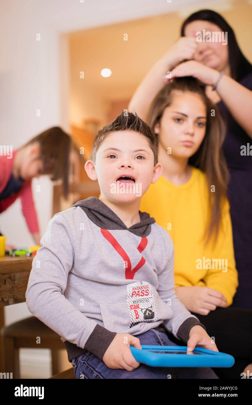 Glücklicher Junge mit Down-Syndrom mit digitaler Tablette Stockfoto