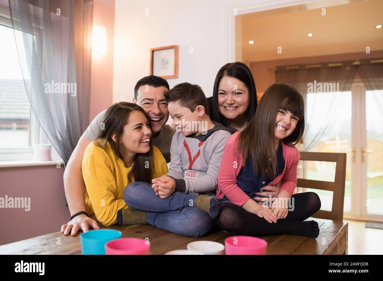 Porträt glückliche Familie mit Down-Syndrom-Kind am Esstisch Stockfoto