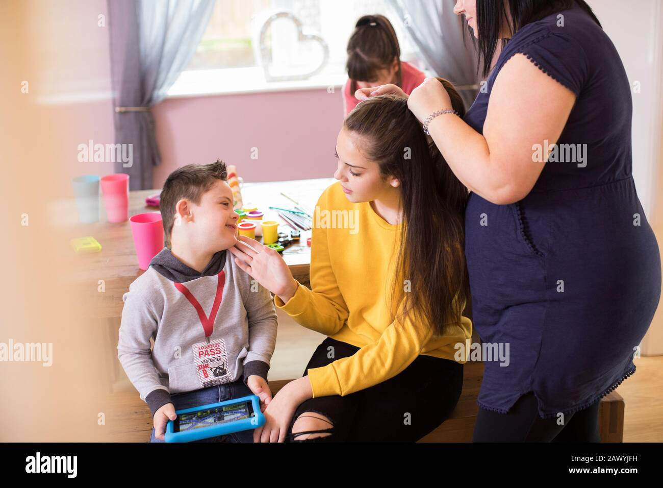 Glückliche Familie mit Daen-Syndrom-Kinderbindung im Speisesaal Stockfoto