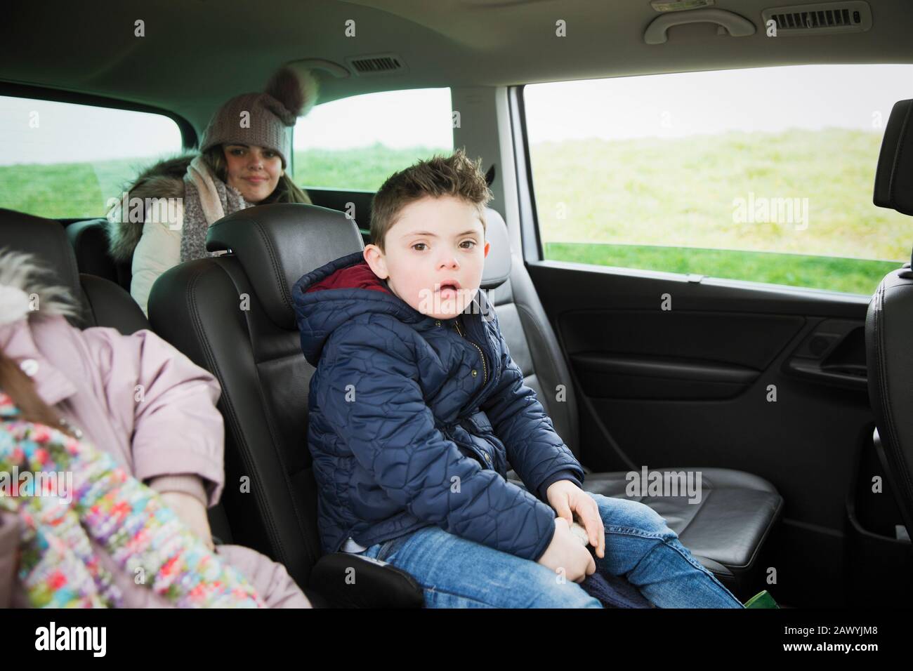 Portrait Junge mit Daisen-Syndrom auf dem Rücksitz des Minibus Stockfoto
