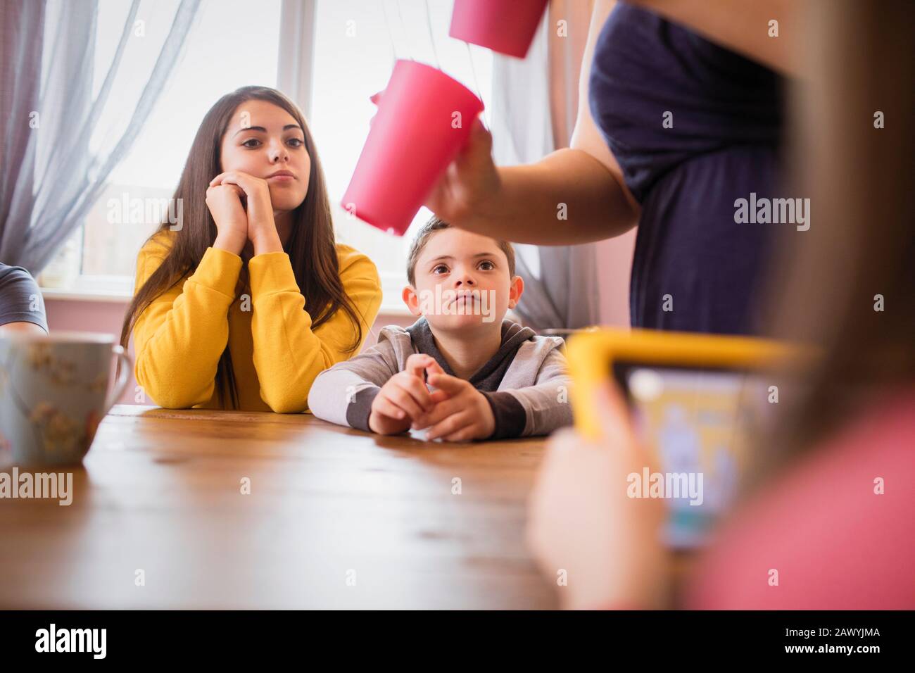 Junge mit Down-Syndrom und Schwester am Esstisch Stockfoto