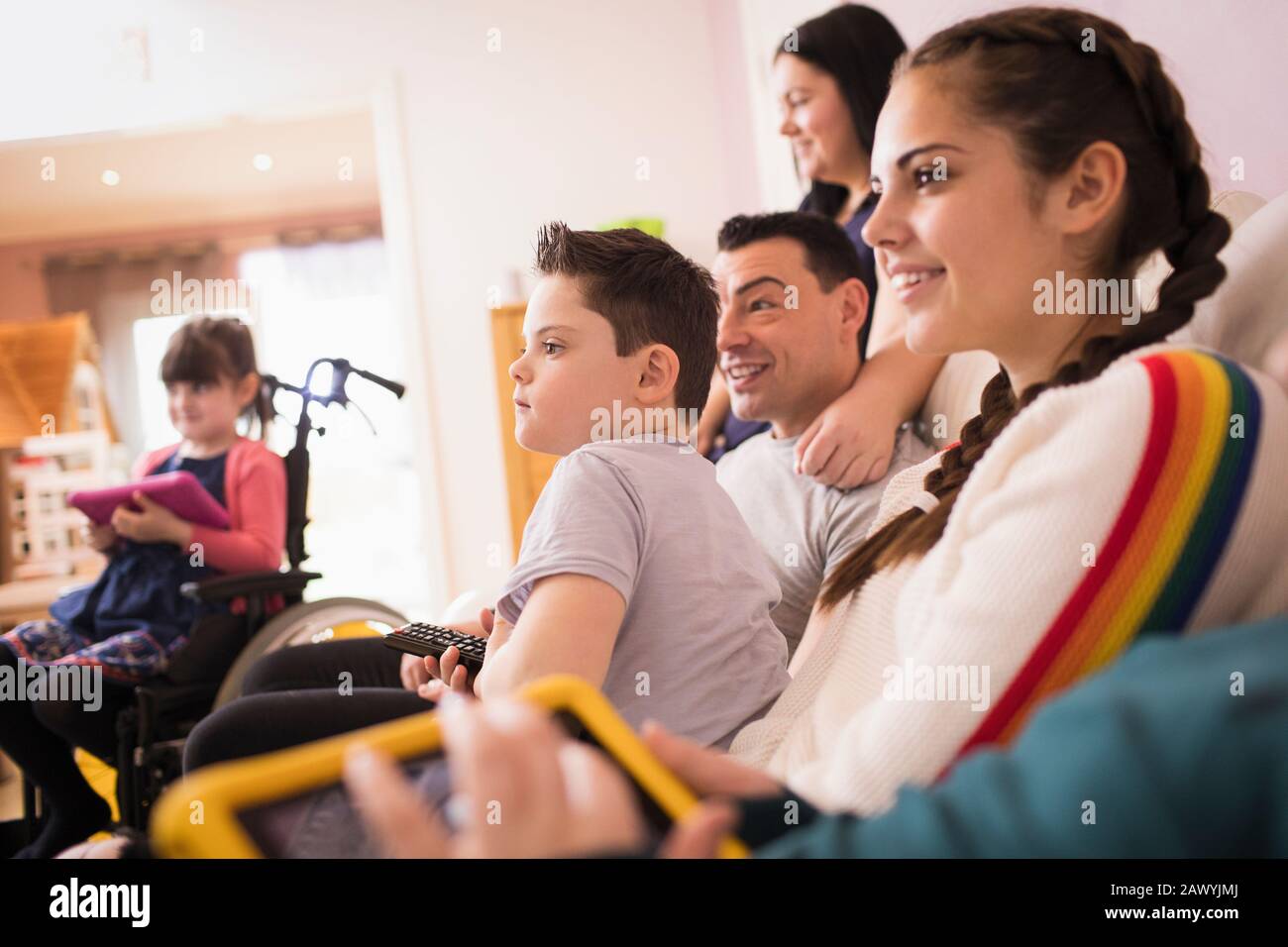 Fröhliche Familie, die Fernsehen auf dem Sofa im Wohnzimmer sieht Stockfoto