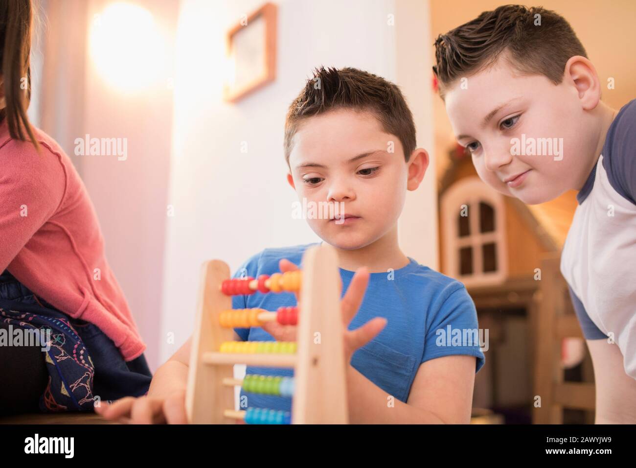 Junge mit Down-Syndrom und Bruder, der mit Spielzeug spielt Stockfoto