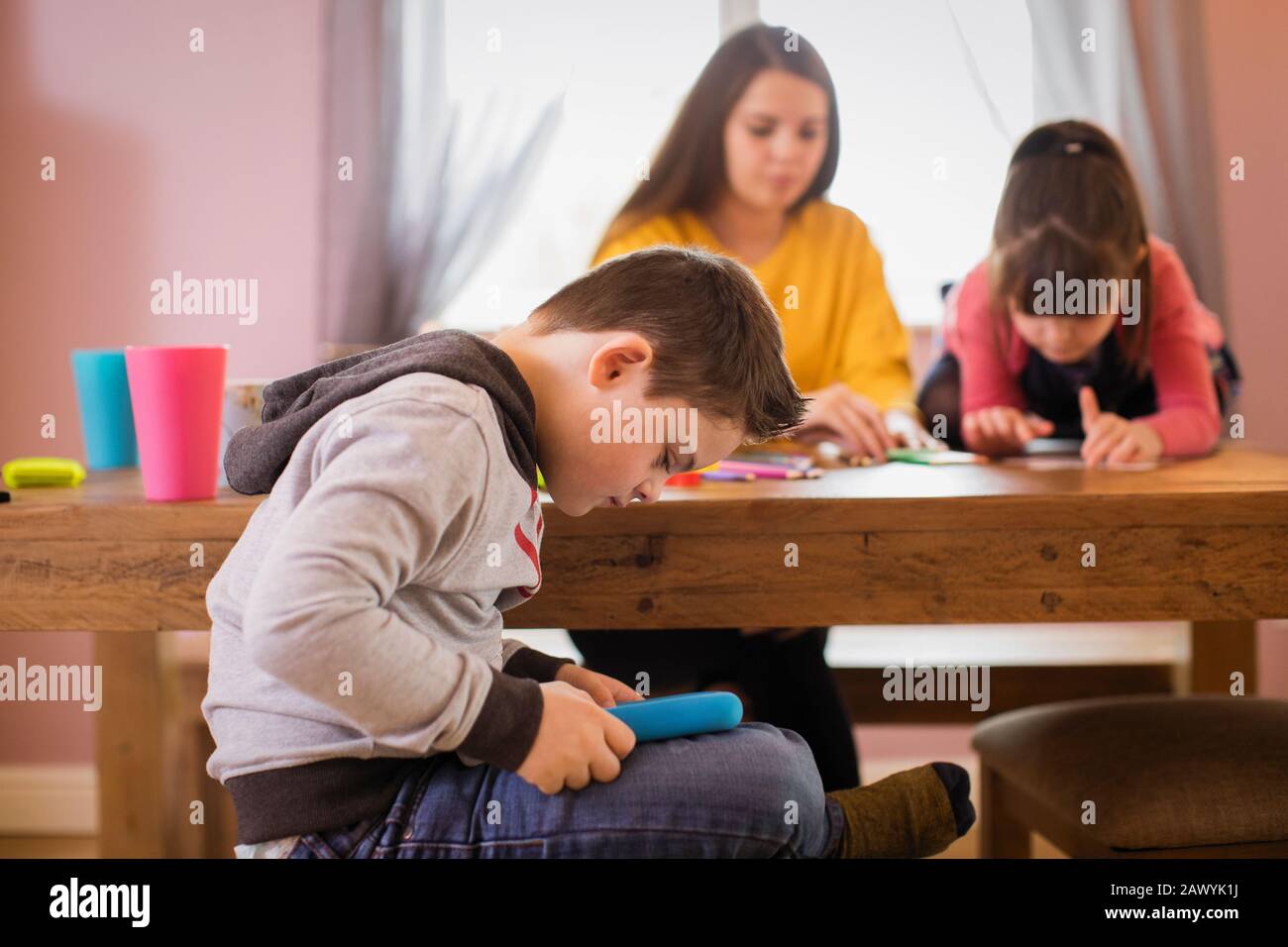 Junge mit Down-Syndrom mit digitalem Tablet im Speisesaal Stockfoto