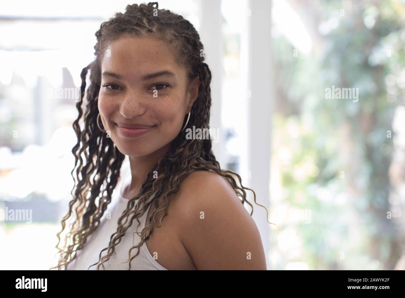 Portrait selbstbewusste, schöne junge Frau mit lockigen Haaren Stockfoto