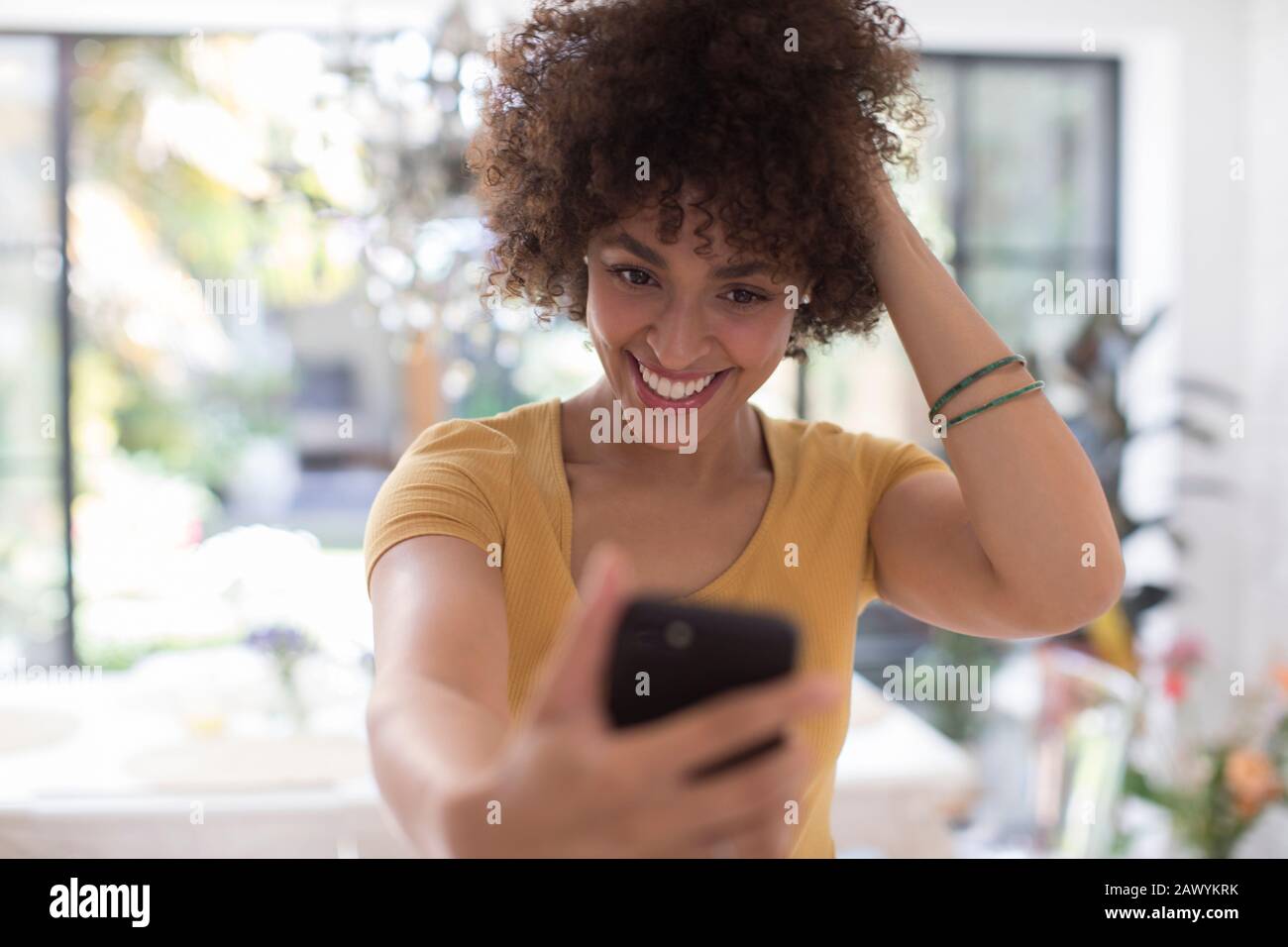 Selbstbewusste lächelnde junge Frau, die selfie mit Kameratelefon nimmt Stockfoto