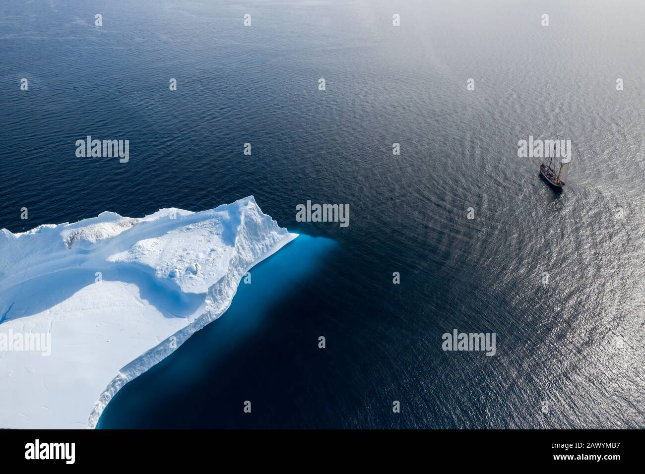 Schiff, das am arktischen Eisberg auf dem sonnigen Atlantik Grönlands vorbeisegelt Stockfoto
