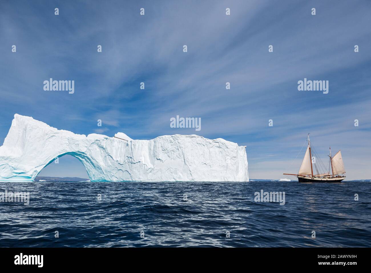 Schiff, das in Richtung des sonnigen majestätischen Eisbergs mit Bogen Grönlands segelt Stockfoto