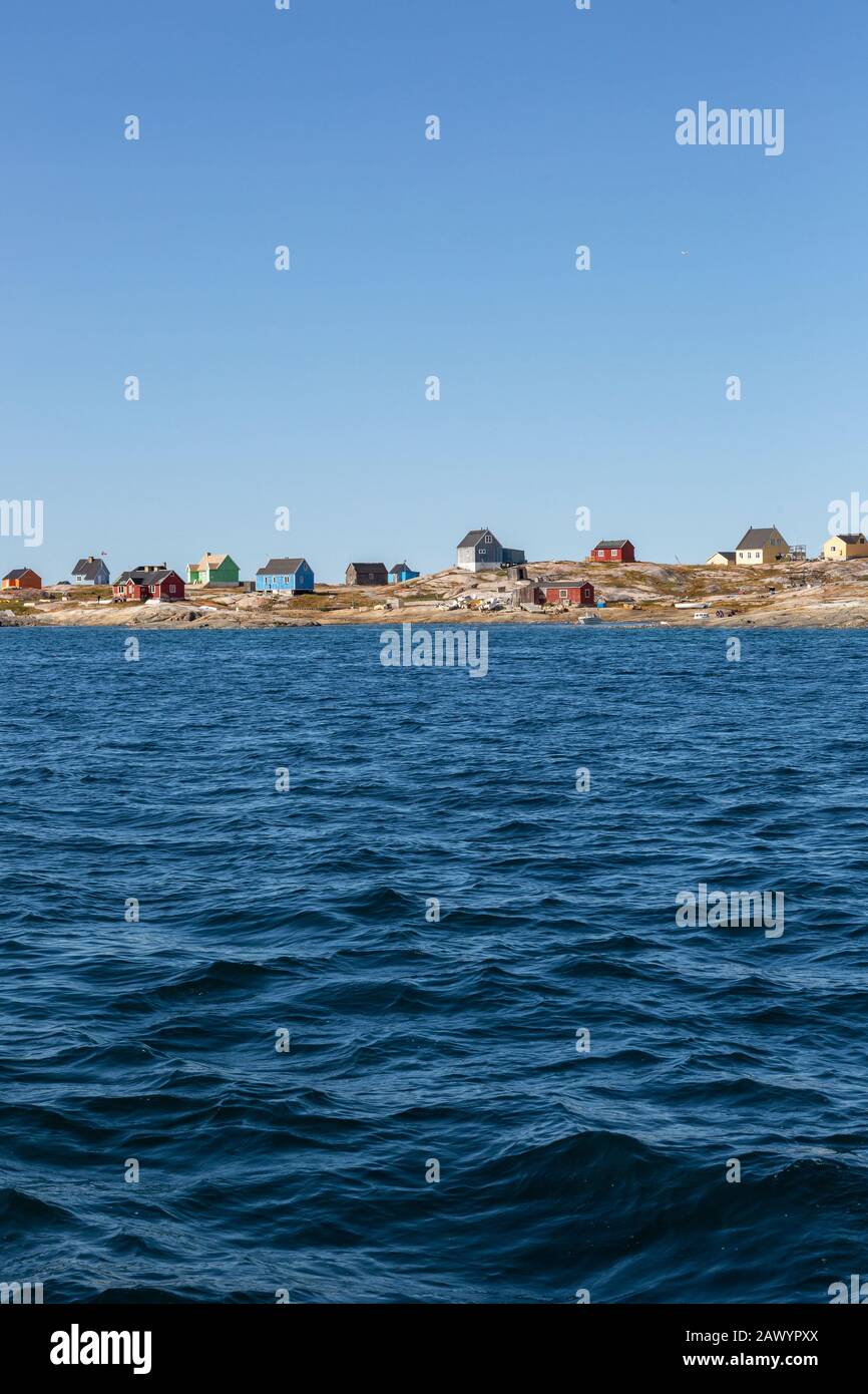 Häuser an sonniger abgelegener Meeresküste Disko Bay Westgrönland Stockfoto