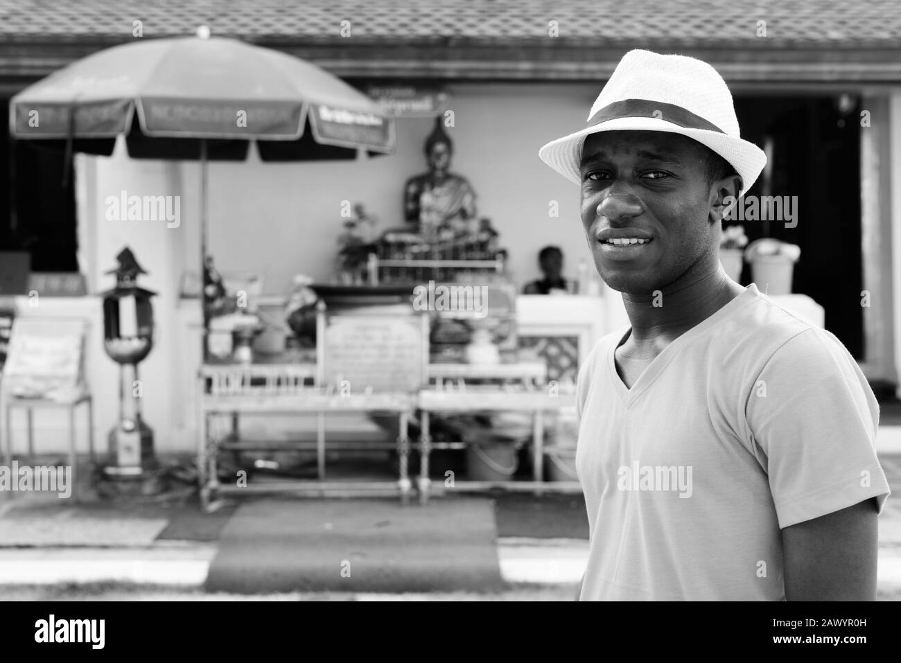 Junger afrikanischer Tourist gegen den Blick auf den Buddhaschrein im Wat Arun Tempel Stockfoto