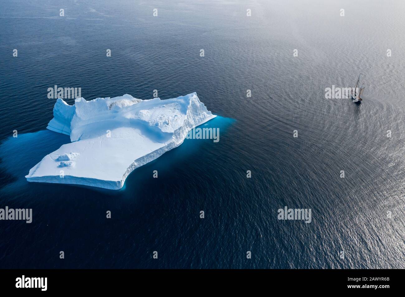Schiff, das an majestätischen Eisbergformationen auf dem blauen Atlantischen Ozean Grönlands vorbeisegelt Stockfoto