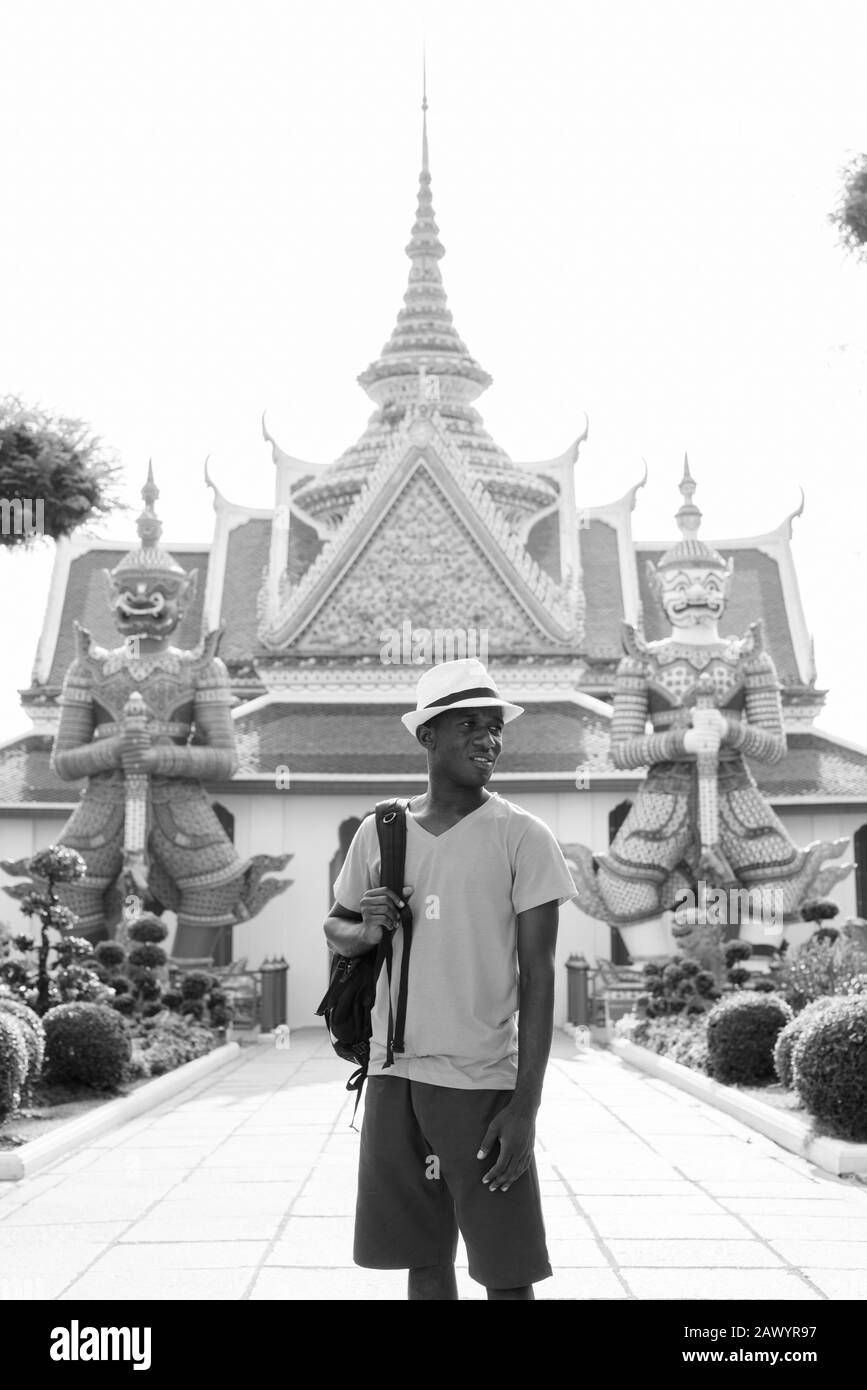 Junger afrikanischer Tourist, der vor dem Wat Arun Tempel denkt Stockfoto